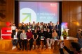 Gruppenfoto der Siegerteams auf einer Bühne. ca. 30 Menschen mit Siegerpokalen in den Händen und Urkunden.