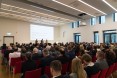 Publikum 155 Personen  schaut in Richtung Bühne, wo 2 Pesonen im Podium reden. 30 Jahre Eignekapital in Brandenburg