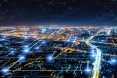 Nachansicht über eine beleuchtete City mit virtuellen Verbindungslinien darüber