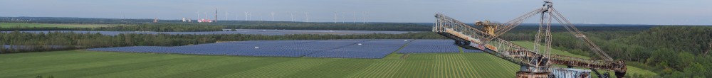 Alter Tagebaubagger mit renaturierter Landschaft und einem Meer an Solarpanelen